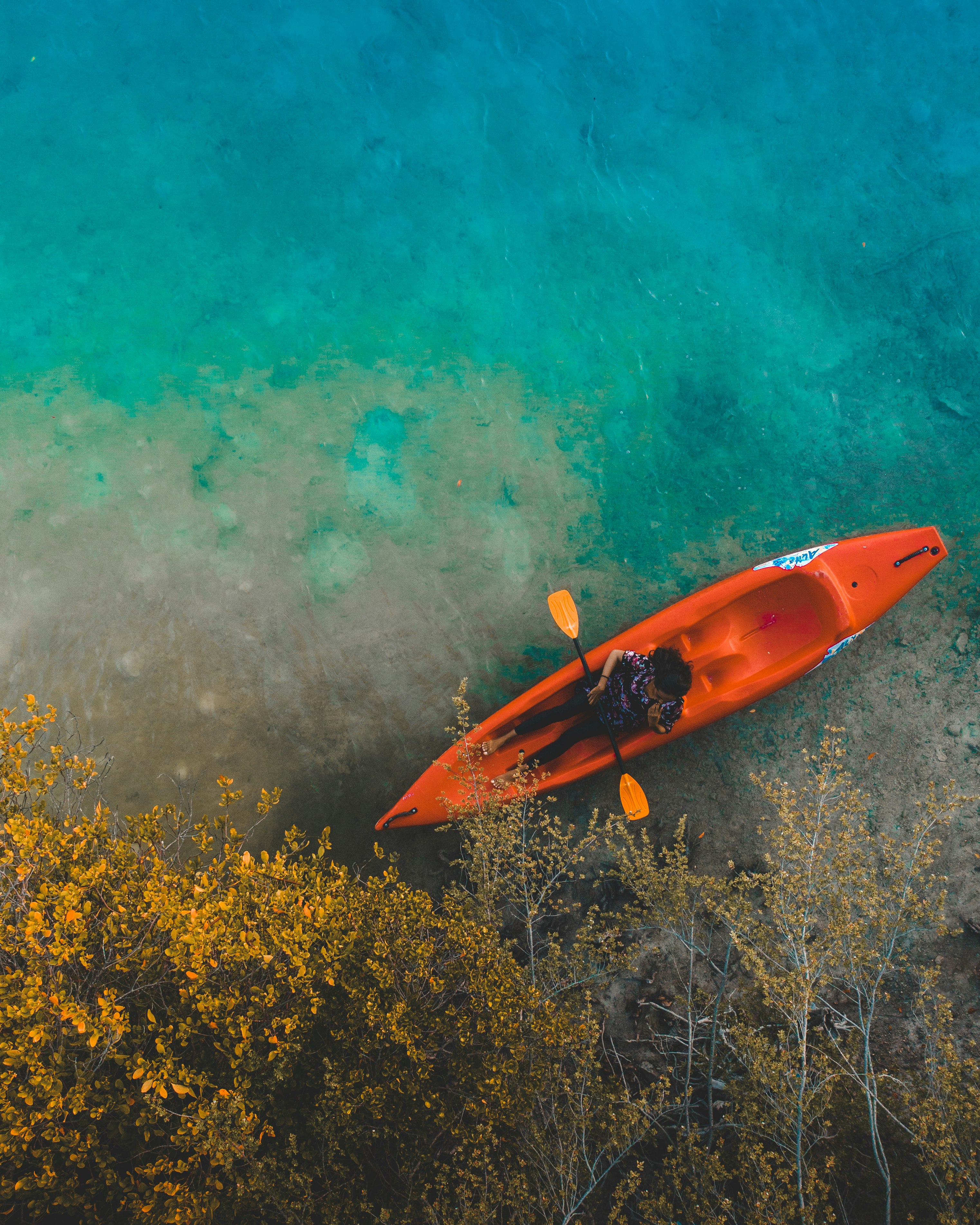 red and yellow kayak on body of water